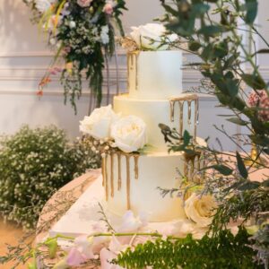 tiered cake with gold drips and roses